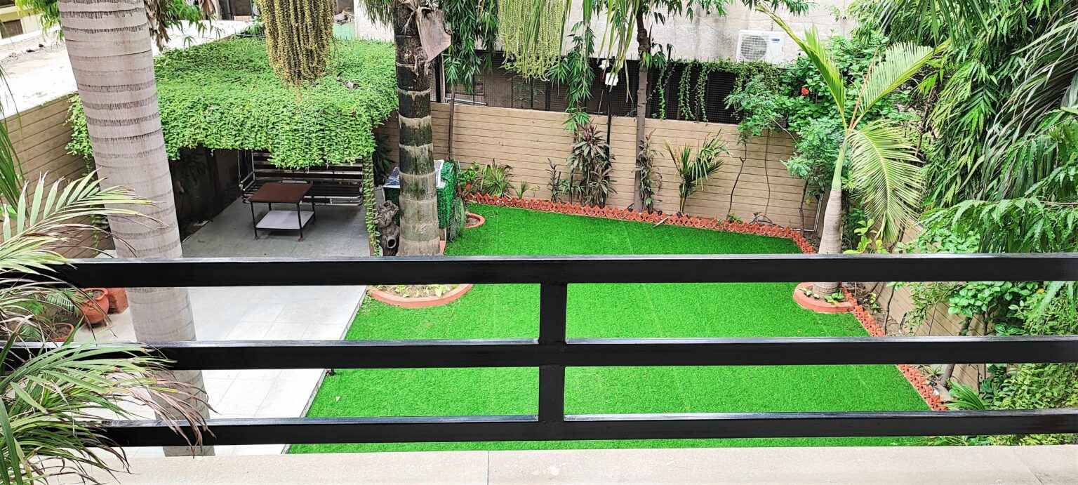 Wide view of Balcony-4 corridor featuring soft green artificial turf flooring