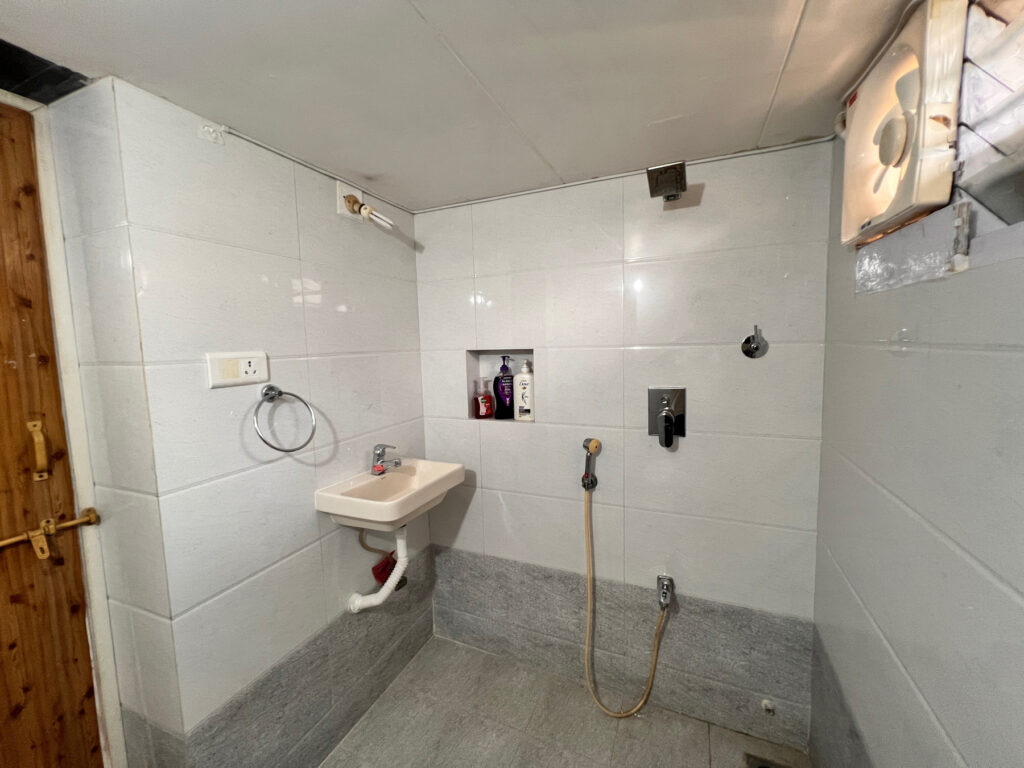 Stylish ceramic washbasin and large mirror in Bathroom 2, featuring modern LED lighting.