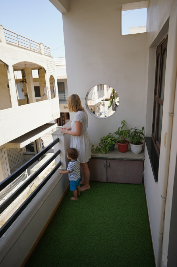 Guest enjoying the street view from Balcony-1 at Homeland Stay